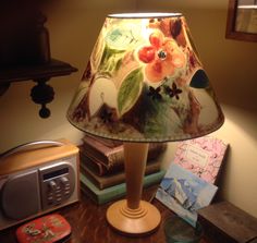 a lamp sitting on top of a wooden table next to a clock and other items