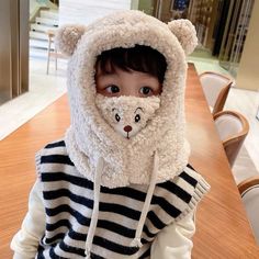 a young child wearing a hoodie with a teddy bear on it's face