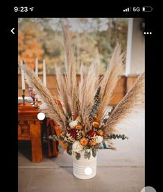 a vase filled with lots of dried flowers