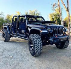 a black jeep parked on top of a dirt field