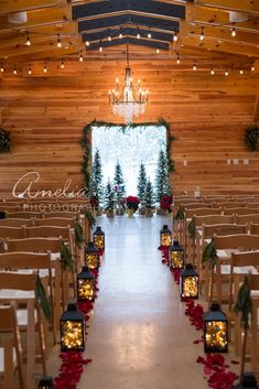 the aisle is decorated with red and green flowers, pine trees and lanterns for christmas