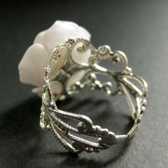 "Bright white resin has been used to create a delicate handmade resin rose that has then been set upon an adjustable filigree ring base in this pretty handmade flower ring that is designed to be adjustable from size 6 and up. Flower Size: 19mm To see this ring in all available colors, check here: http://etsy.me/1gr9dLc The base for this delicate rose ring is adjustable, which makes this handmade flower ring comfortable no matter the size of the wearer's fingers (size 6 and up) as well as ideal f Delicate Adjustable Flower Ring For Wedding, Delicate Flower Ring For Weddings, Adjustable Rose Design Jewelry Ring, Elegant Resin Jewelry For Wedding, Elegant White Adjustable Flower Ring, Delicate Adjustable Rose-colored Jewelry, Delicate Adjustable Rose Jewelry, Nickel Free Elegant Crystal Ring For Jewelry Making, Delicate Adjustable White Flower Ring