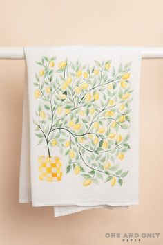 a towel hanging on a clothes line with lemons painted on it