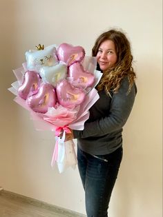 a woman holding a bouquet of pink and white teddy bears