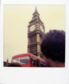 the big ben clock tower towering over the city of london as people look on from across the street