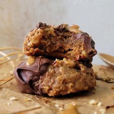 two cookies are stacked on top of each other with chocolate and nuts in the middle