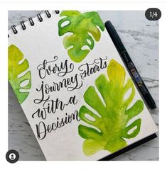 a notebook with some green leaves on it and the words every journey starts with a decision