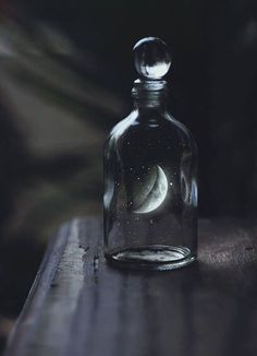 a bottle that has some kind of liquid in it with the moon and stars inside