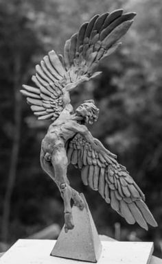 a statue of a man with wings on top of a table