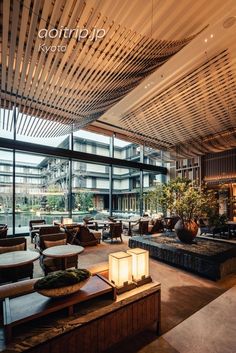 the interior of a modern restaurant with large windows and wooden ceiling tiles on the walls