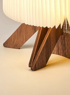 a wooden table with a white lamp on it's side and an object in the middle