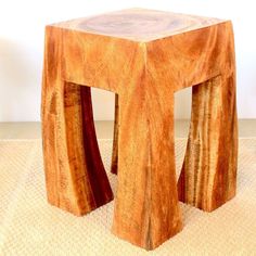 a small wooden stool sitting on top of a carpet