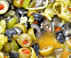 olives, peppers and other vegetables are mixed together to make an italian dish with oil