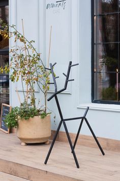 a potted plant sitting on top of a wooden floor next to a metal stand