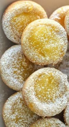 powdered sugar covered donuts in a white box