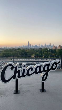 the chicago sign on top of a parking lot in front of a cityscape