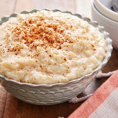 a bowl filled with mashed potatoes on top of a wooden table