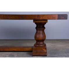 a large wooden table with two legs on the top and one leg raised up to the ground