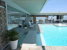 an indoor swimming pool with lounge chairs next to it