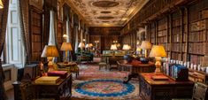 the library is filled with many books and lamps on either side of the desks