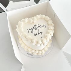 a heart shaped cake in a box with congratulations baby written on the top and bottom