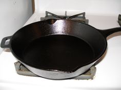 an old cast iron skillet sitting on top of a stove