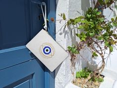 Elevate your summer style with our White Clutch Bag featuring a captivating evil eye (nazar) design, blending the timeless allure of Greek culture with modern elegance. This chic accessory embodies the serene, sun-soaked charm of the Greek islands, making it the perfect handbag for those unforgettable summer evenings in Santorini, Mykonos, or the bustling streets of Athens. With its sleek white base and striking evil eye pattern, this clutch embodies both simplicity and sophistication, offering a look that's effortlessly stylish. Inspired by the essence of a Greek summer, this white clutch exudes a sense of relaxed luxury that pairs beautifully with any outfit, from a flowing sundress to a tailored evening ensemble. Its clean white color complements the intricate blue evil eye, a symbol of White Rectangular Pouch For Daily Use, Rectangular White Pouch For Daily Use, White Clutch Bag As Gift, White Clutch Bag For Gifts, White Clutch Bag For Gift, Everyday White Envelope Clutch, White Envelope Bag For Everyday Use, Handmade White Clutch For Daily Use, White Rectangular Pouch