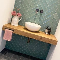 a bathroom with a wooden shelf holding a bowl sink