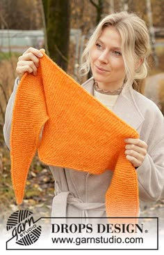 a woman holding an orange knitted scarf in front of her face with the words drops design on it