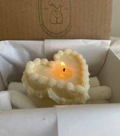 a small white candle is in a box