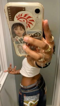 a person taking a selfie in front of a mirror with her cell phone up to her ear