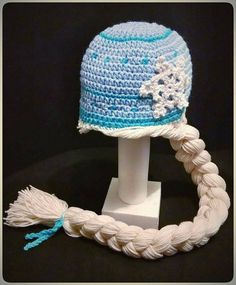 a crocheted hat with braids is on display