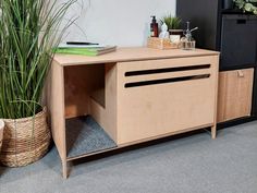 a wooden cabinet sitting next to a potted plant