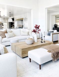 a living room filled with white furniture and lots of pillows on top of it's couches