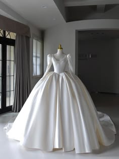 a white wedding dress on display in a room