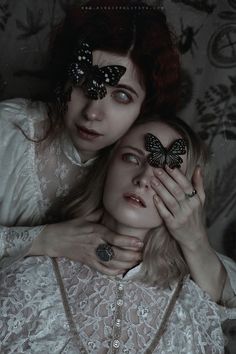 two women with butterflies on their faces