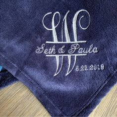 two blue towels with the initials and date on them