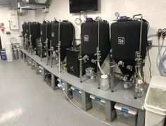 a row of water filtrators lined up in a room