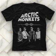 the arctic monkeys t - shirt is shown on a tile floor with an image of two men wearing sunglasses