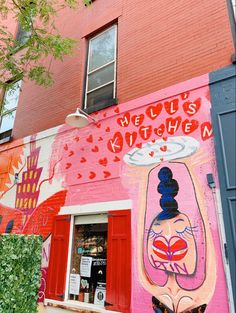 there is a mural painted on the side of this building that says hello kitty's kitchen