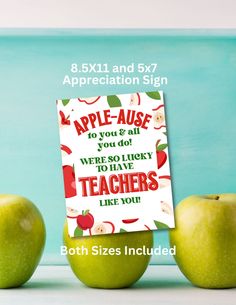 two green apples sitting next to each other with an apple - ause sign on them