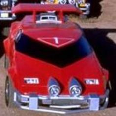 a group of toy cars sitting on top of a dirt field next to each other