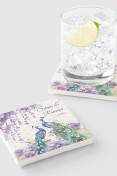 two square coasters with a water glass and a lemon slice on the top one