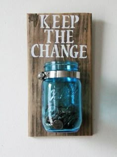 a blue mason jar hanging on a wooden sign with the words keep the change printed on it