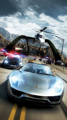 two cars driving on a road with a helicopter flying over them in front of the camera