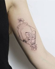 a woman's arm with a tattoo on it and an image of a cat in a jar