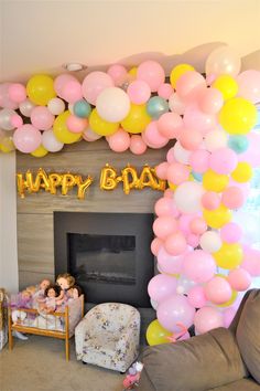 a living room filled with balloons and a baby in a crib next to a fire place