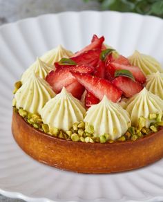 there is a small cake with strawberries on top and pistachios in the middle