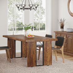 a dining room table with chairs and a bowl of fruit on the table next to it