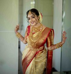 a woman in a yellow and red sari with her hands out to the side